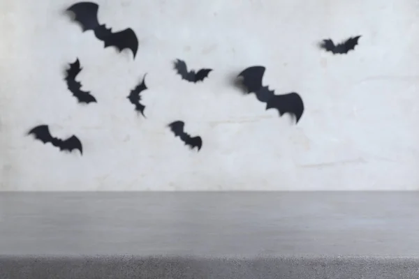 Gri Duvarın Yanında Üzerinde Siyah Yarasalar Olan Taş Bir Masa — Stok fotoğraf