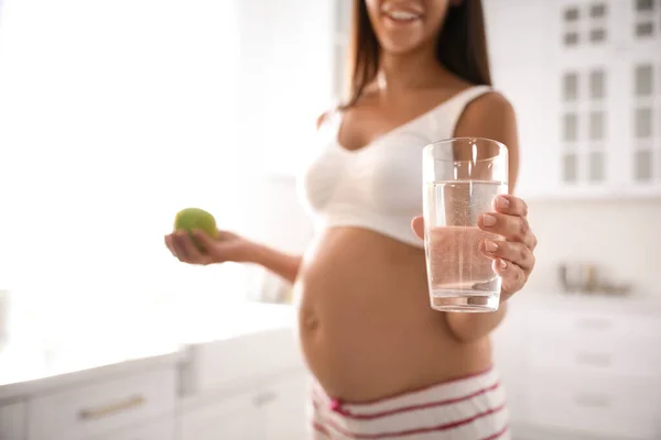 Młoda Kobieta Ciąży Szklanką Wody Jabłkiem Kuchni Skup Się Drinku — Zdjęcie stockowe