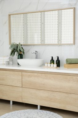 Modern banyo içinde şık bir ayna ve kap lavabosu var.