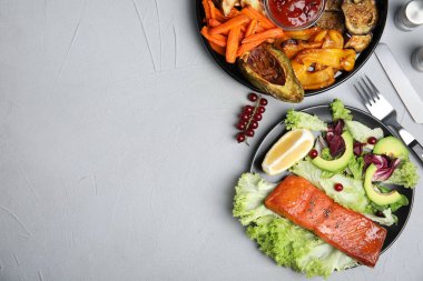 Lezzetli pişmiş somon balığı ve gri masada servis edilen taze salata, yazı için yeri olan düz bir yer. Kızartmadan sağlıklı yemekler.