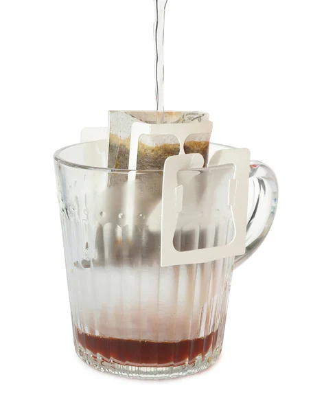 白に単離されたドリップコーヒーバッグ付きガラスカップにお湯を入れる — ストック写真
