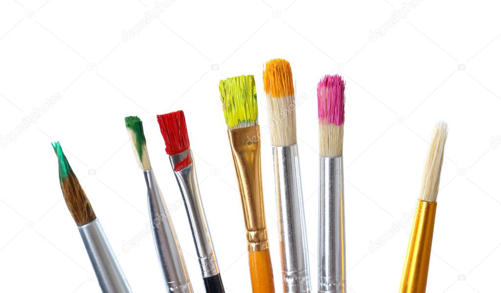 Different brushes with paints on white background