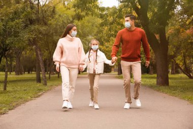 Coronavirus salgını sırasında parkta birlikte yürüyen sevimli bir aile.