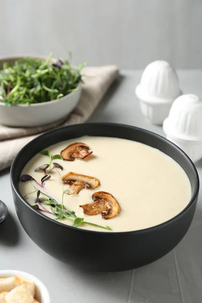 Delicious cream soup with mushrooms on light table