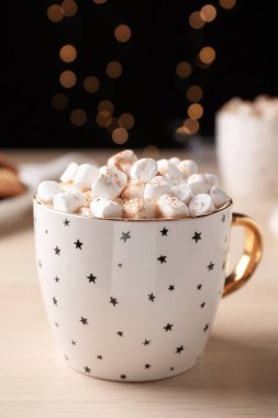 Tahta masanın üzerinde lokum olan bir fincan sıcak içecek.