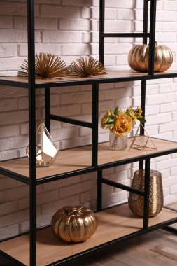 Beyaz tuğla duvarın yanında farklı dekorlarla raflarda. İç tasarım