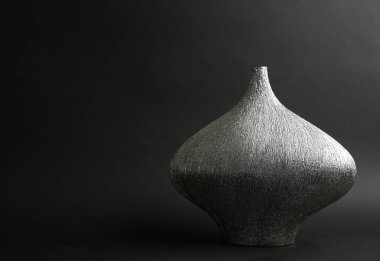 Siyah arkaplanda gümüş seramik vazo, metin için boşluk
