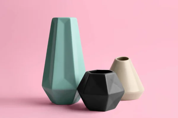 Stylish empty ceramic vases on pink background