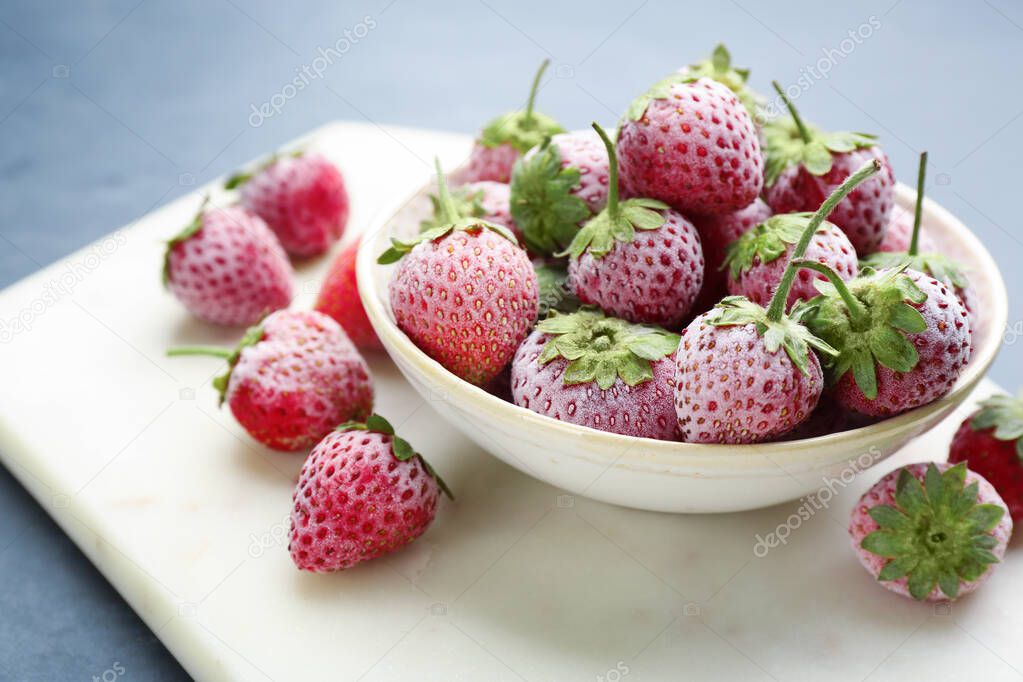 Tasty frozen strawberries on white board, closeup