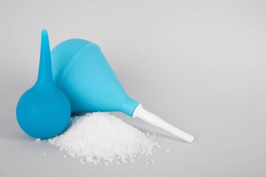 Enemas ve gri arkaplanda tuz yığını, metin için boşluk. Tıbbi tedavi