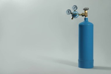 Açık gri arka planda tıbbi oksijen tankı. Metin için boşluk