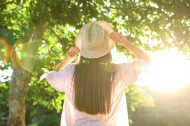 Güneşli bir günde, açık havada şapkalı genç bir kadın.