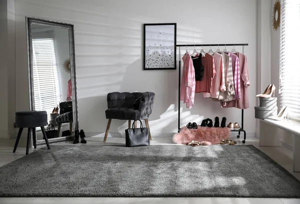 衣類ラックと快適な椅子とドレッシングルームのインテリア — ストック写真