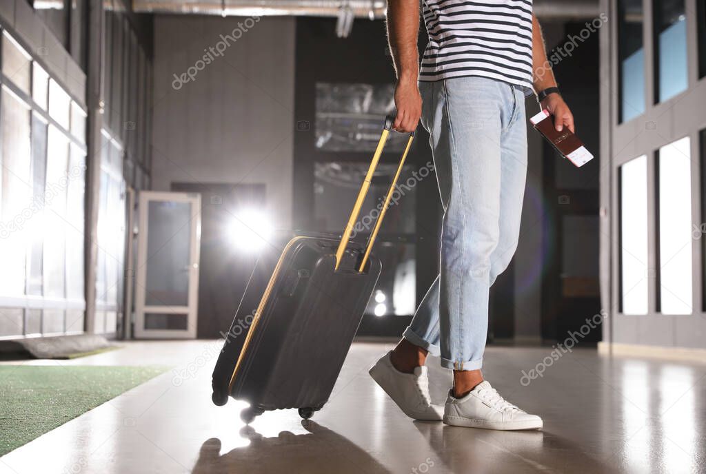 Man with black travel suitcase in airport