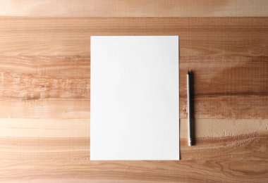 Tahta zemin üzerinde boş kağıt çarşaf ve kalem, düz yatıyordu. Metin için boşluk