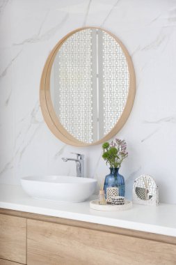 Modern banyo içinde şık bir ayna ve kap lavabosu var.