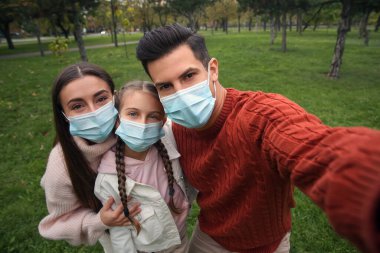 Coronavirus salgını sırasında parkta selfie çeken sevimli bir aile.