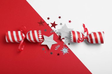 Renkli arka planda parlak konfeti olan açık Noel krakeri, üst görünüm