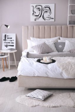 Yatak odasının içi minderlerle ve güzel resimlerle dolu.