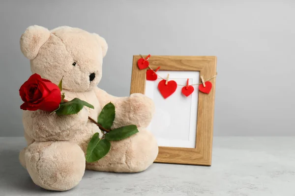 Niedlicher Teddybär Mit Roter Rose Und Gestell Auf Hellgrauem Steintisch — Stockfoto