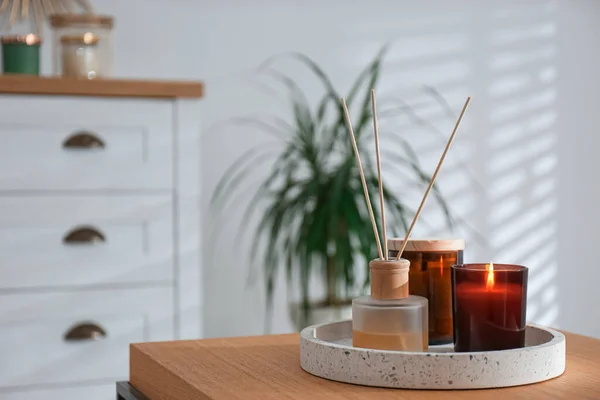 Air reed freshener and candles on table in living room. Space for text