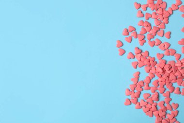 Açık mavi arka planda parlak kalp şeklinde serpiştirmeler, düz uzanma. Metin için boşluk