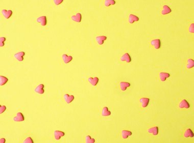 Parlak kalp şeklinde serpintiler sarı arka planda, düz uzanmış