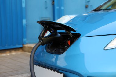 Dışarıdaki istasyondan modern elektrikli araba şarj ediliyor.