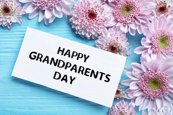 Piękne Kwiaty Kartka Frazą Happy Grandparents Day Jasnoniebieskim Drewnianym Tle — Zdjęcie stockowe