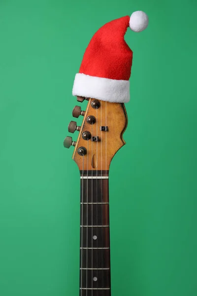 Gitaar Met Kerstmuts Groene Achtergrond Kerstmuziek Concept — Stockfoto