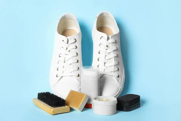 Composition with stylish footwear and shoe care accessories on light blue background