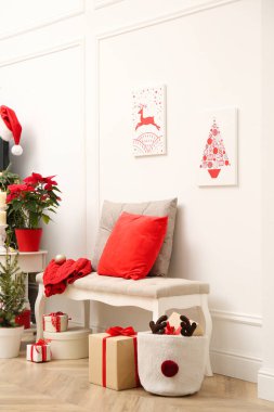 Aydınlık odada Noel temalı resimler ve şenlikli dekorasyonlar. İç tasarım