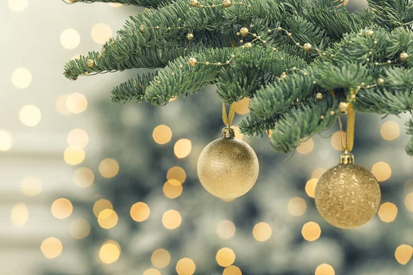 Zlaté Vánoční Koule Visící Jedli Proti Rozmazaným Slavnostním Světlům — Stock fotografie