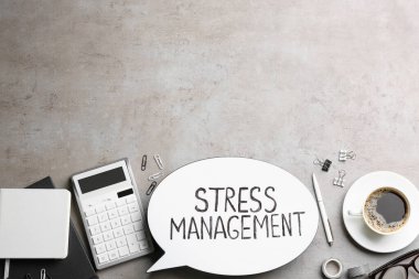 Stres Yönetimi ve ofis malzemelerinin gri masanın üzerinde durduğu düz kompozisyon. Metin için boşluk