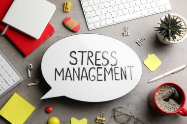 Gri masa üzerinde Stres Yönetimi ve ofis malzemelerinin yer aldığı düz kompozisyon