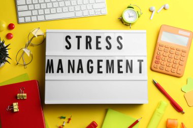 Sarı zemin üzerinde stres yönetimi ifadesi olan ışık kutusunun düz kompozisyonu