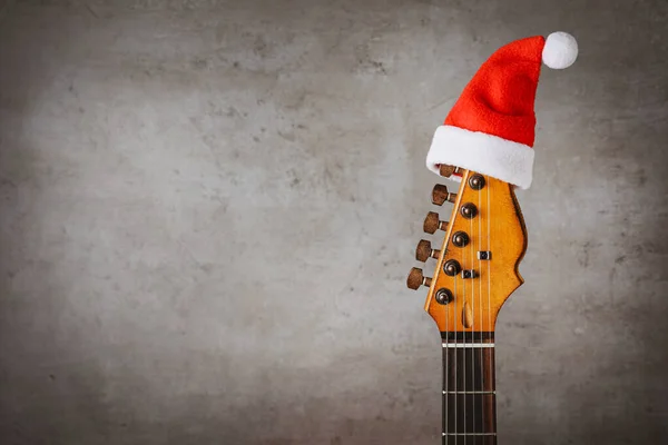 Gitaar Met Kerstmuts Grijze Achtergrond Ruimte Voor Tekst Kerstmuziek — Stockfoto
