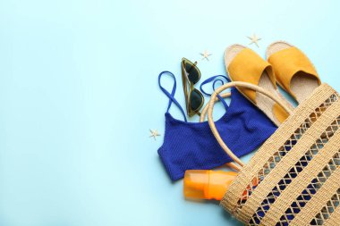 Açık mavi arka planda plaj aksesuarları, düz yatış. Metin için boşluk