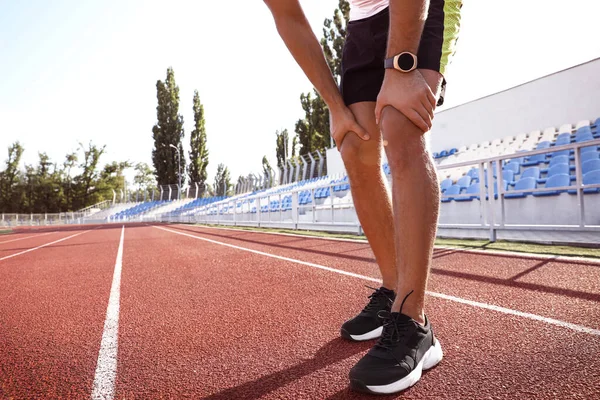 Man with fitness tracker after training at stadium, closeup