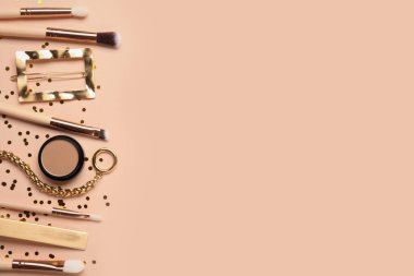 Bej arka planda makyaj fırçaları olan düz bir kompozisyon. Metin için boşluk