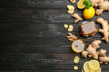 Zencefil ve diğer doğal soğuk algınlığı ilaçları siyah ahşap masada, düz yerde. Metin için boşluk