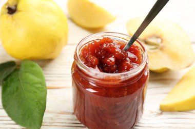 Lezzetli ayva reçeli ve beyaz ahşap masada meyveler