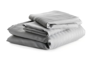Stack of clean bed sheets isolated on white clipart