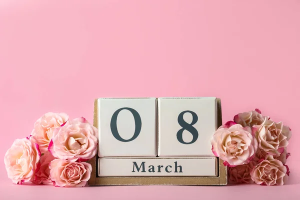 木のブロックカレンダー3月8日の日付とピンクの背景にバラ テキストのためのスペース 国際女性デー — ストック写真