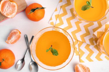 Lezzetli mandalina jölesi ve beyaz ahşap masa üzerinde taze meyveler.