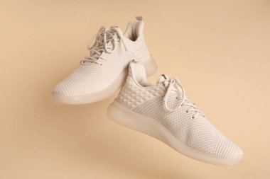 Bej arka planda şık spor ayakkabılar.