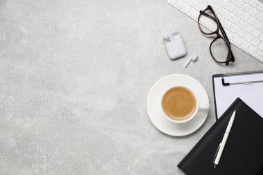 Gri masanın üzerinde bir fincan kahve ve bilgisayar klavyesiyle düz bir kompozisyon vardı. Metin için boşluk
