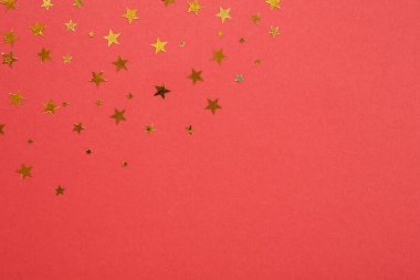 Kırmızı arka planda yıldız şeklinde konfeti. Metin için boşluk