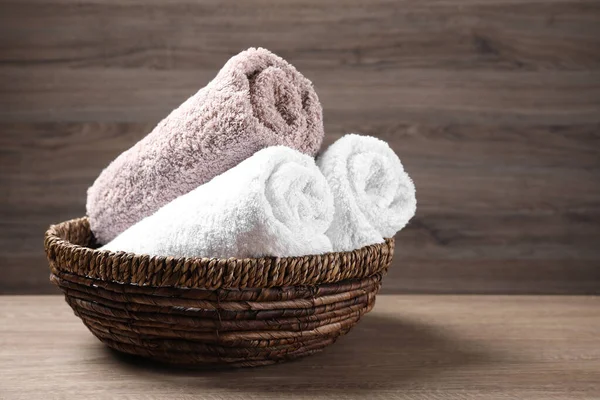 Rolled Soft Towels Wicker Basket Wooden Table Space Text — Stock Photo, Image