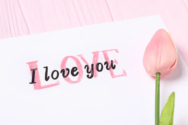 有文字的卡片我爱你 还有粉色木制背景的郁金香 — 图库照片